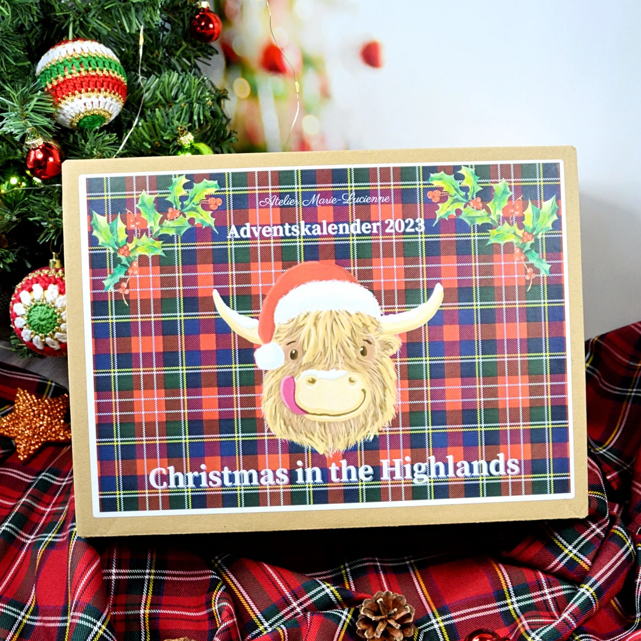 Christmas in the Highlands Adventskalener mit Highland Coo vor Tartan Hintergrund