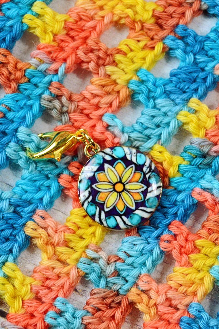 Klassischer Maschenmarkierer Strohblume auf Häkelhintergrund Klassischer Maschenmarkierer Strohblume auf Häkelhintergrund
